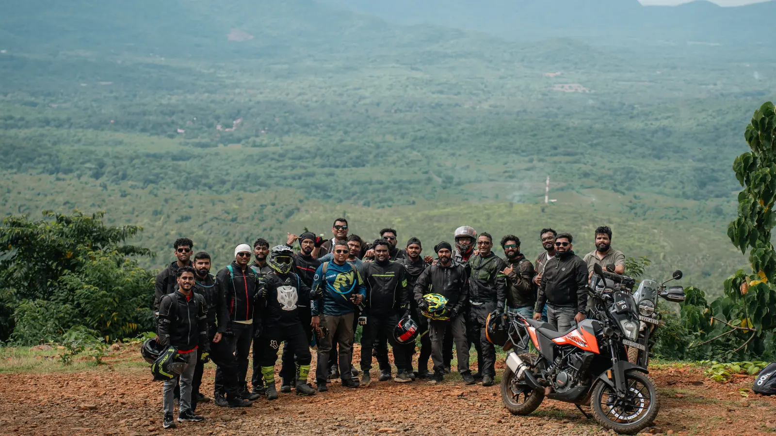 Riders gather for a group photograph at a scenic hilltop viewpoint after completing an off road training ride.