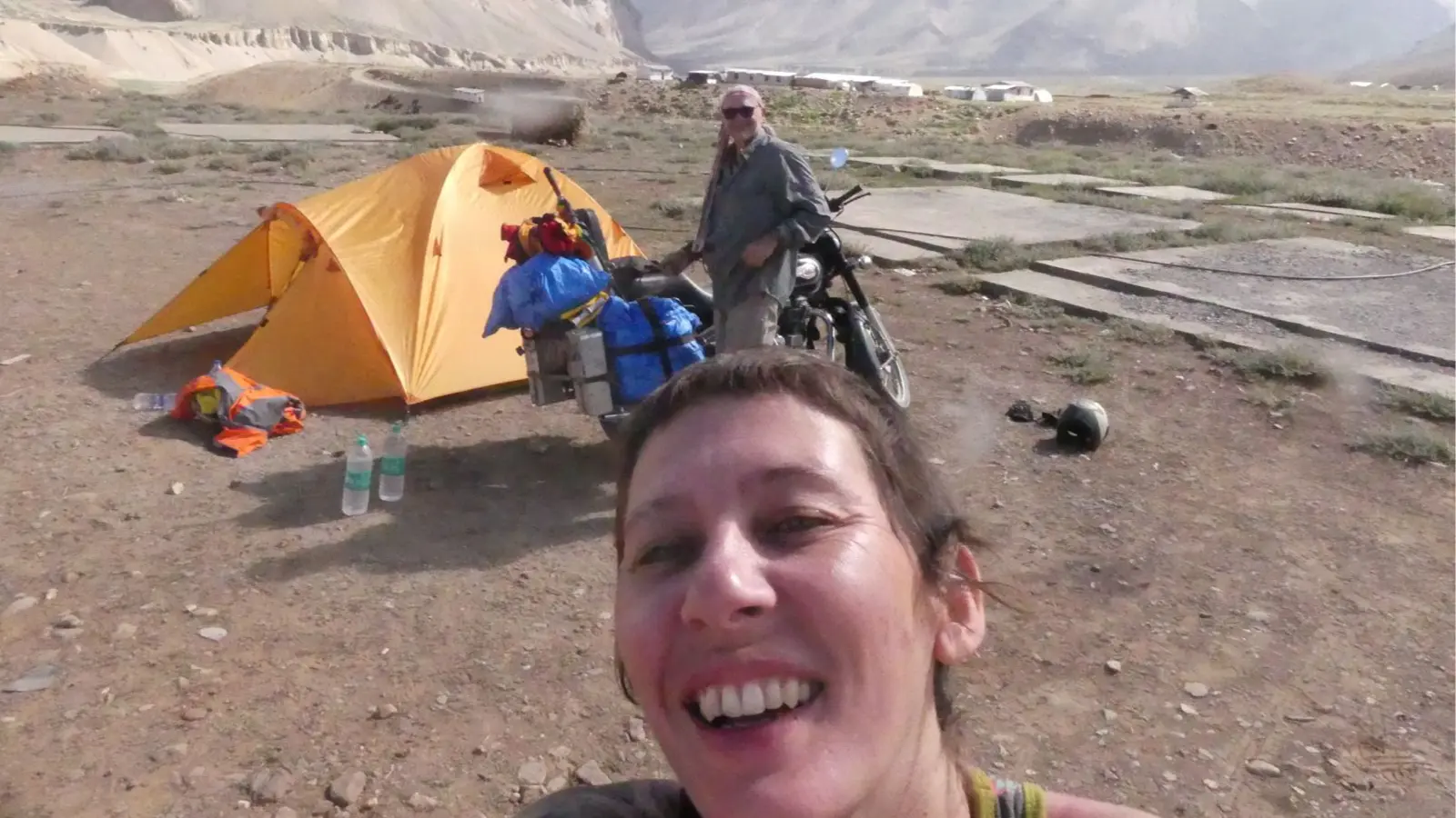 Delphine smiles beside their campsite after another day riding through the Himalayas.
