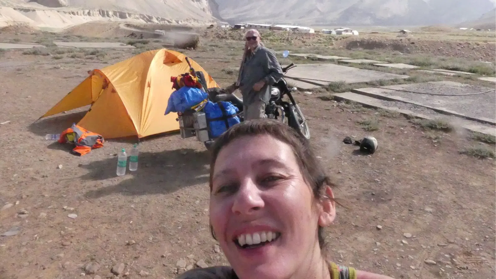 Delphine smiles beside their campsite after another day riding through the Himalayas.